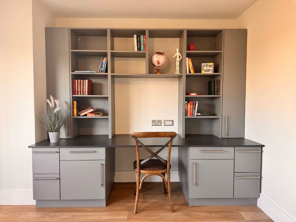 Symmetrical grey fitted study furniture featuring a built-in double desk, open shelving, and sleek modern cabinetry.