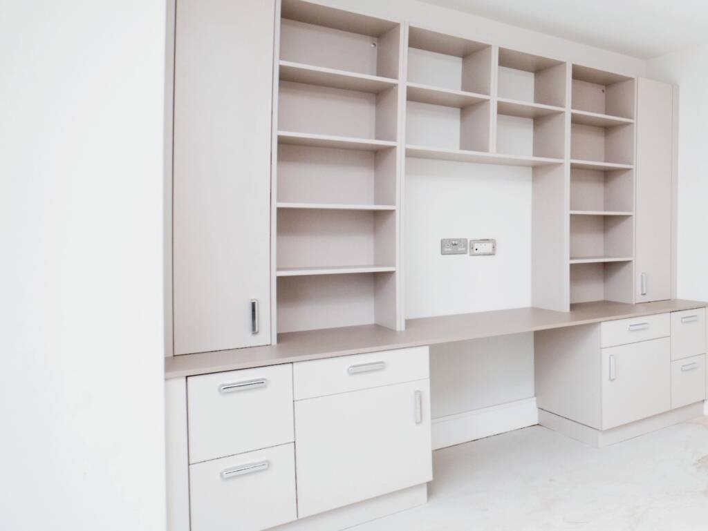 Custom white fitted study furniture with built-in desk, overhead shelving, and integrated storage cabinets in modern home